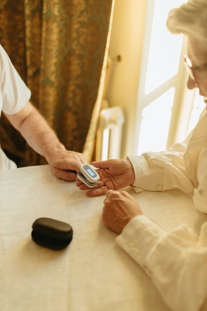 Mastering the First Impression: Your intriguing post title goes here Elderly person using a pulse oximeter indoors for health monitoring.