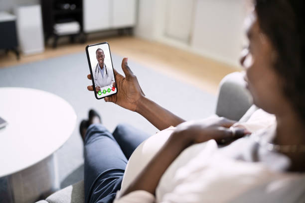 pregnant african women doctor video call on laptop at home pregnant african women doctor video call on laptop at home